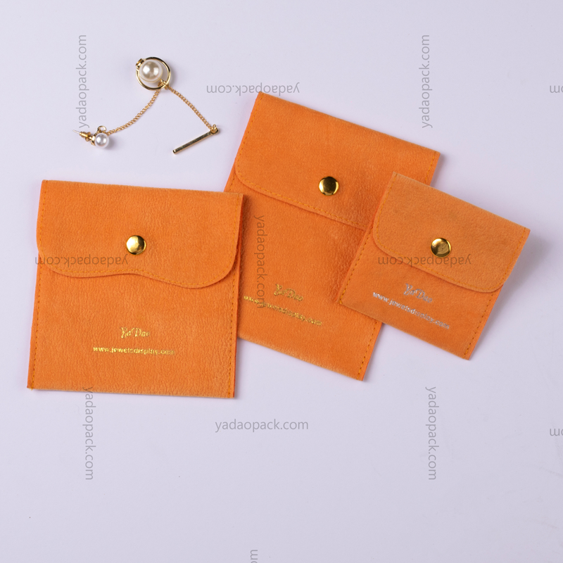 ボタンが付いているオレンジ色のベルベットの袋封筒形の袋