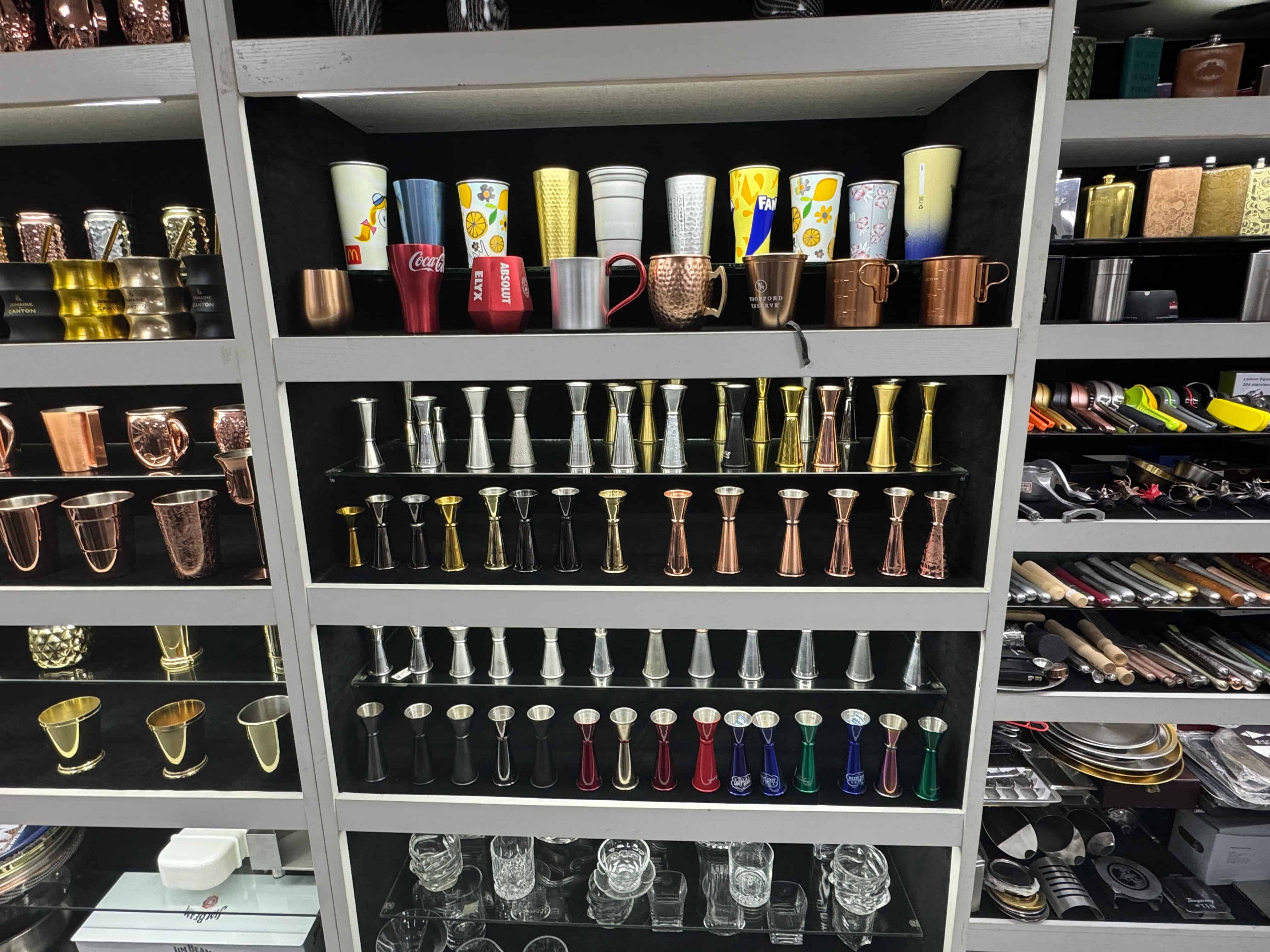 Stainless steel jigger and cup sample showroom with multiple colors, finishes and custom barware options