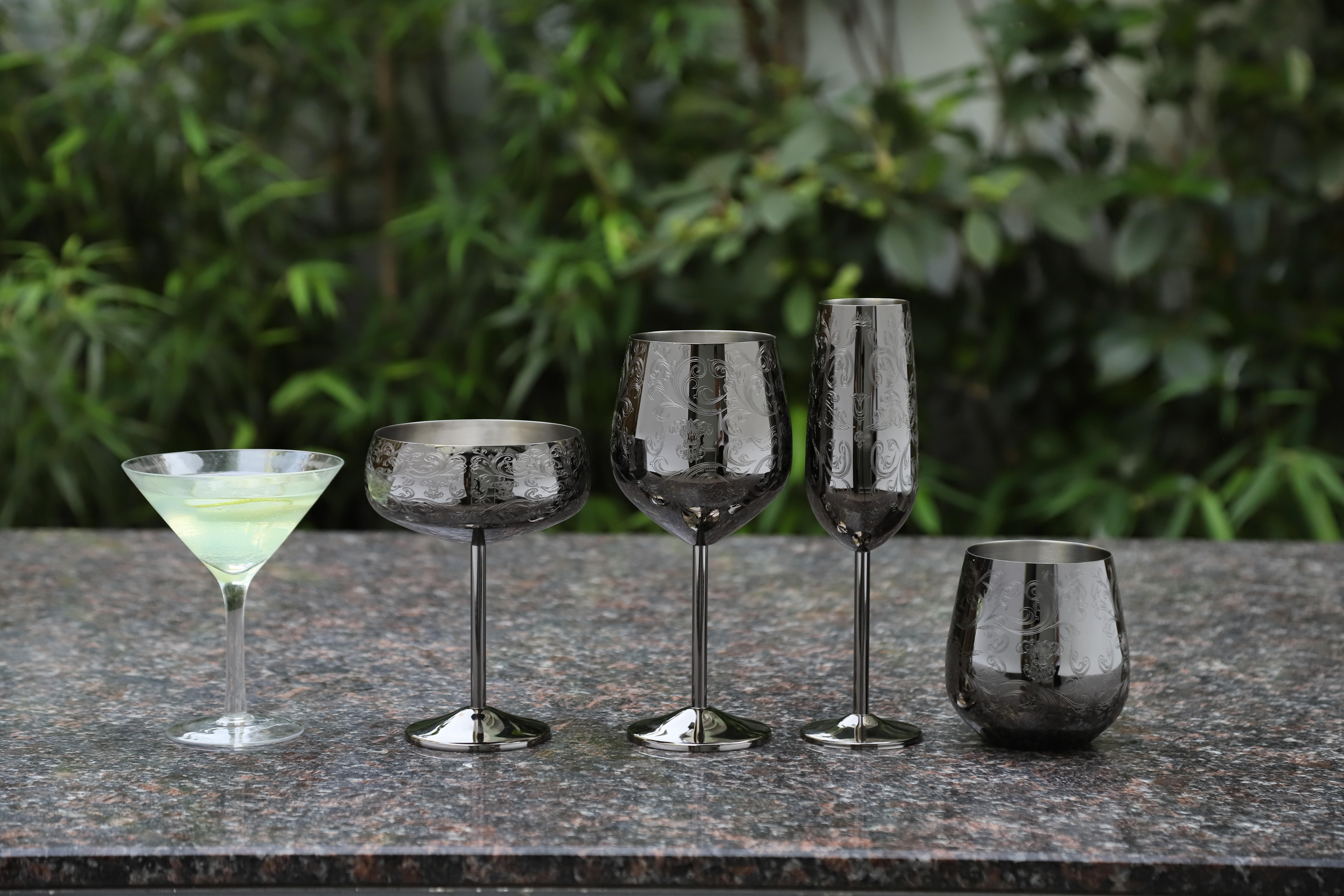 Etched stainless steel wine glass collection with stemmed, stemless and champagne glass designs in dark metallic finish