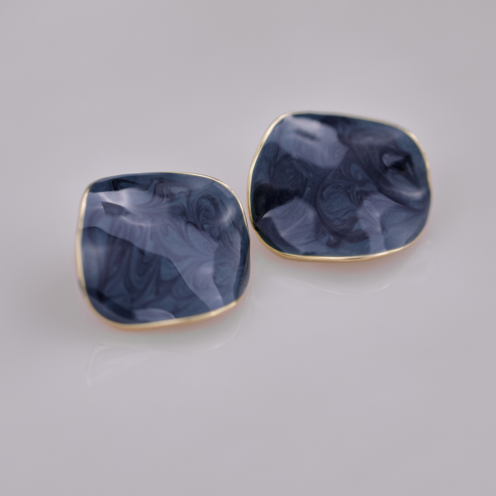 Pendiente de latón chapado en oro con forma irregular que gotea aceite.