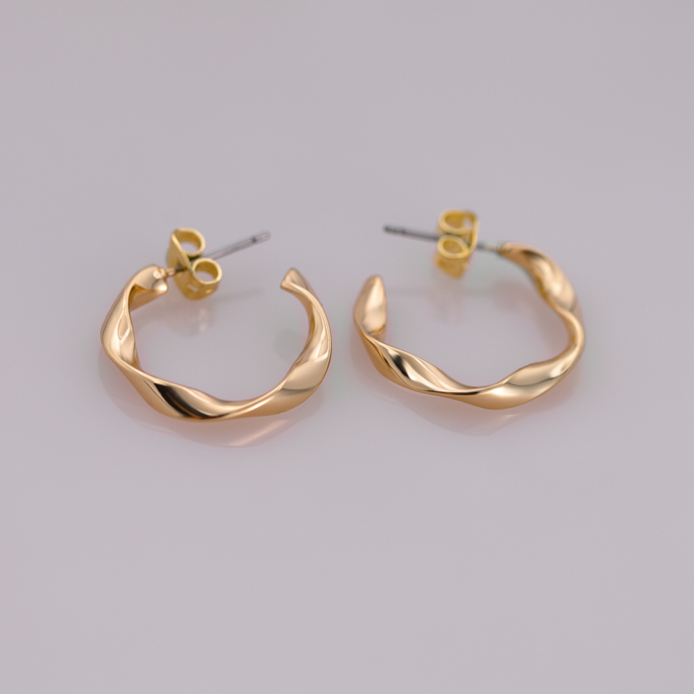 Orecchino a cerchio in ottone a mezza C a forma di cuore geometrico.